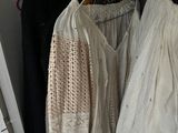 two bags of clothes hanging on a rack in a closet