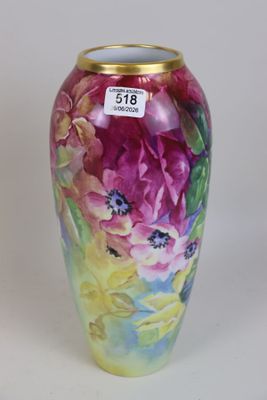un vase avec des fleurs peintes dessus, posé sur une table