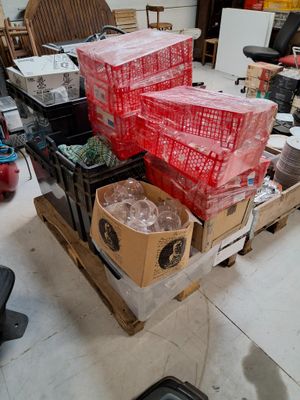 many boxes and crates on a pallet in a room