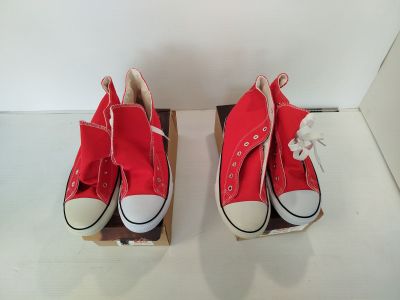 deux paires de Converse rouges exposées dans une vitrine