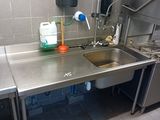 a stainless steel sink in a public kitchen with a faucet