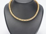 un collier de perles dorées sur un mannequin d'exposition