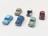 plusieurs petites voitures sont alignées sur une surface blanche