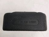 the back of a black leather case with a button on it