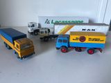 trois camions miniatures posés les uns à côté des autres sur une table