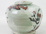 a small vase with a lid sitting on a white surface