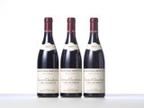 three bottles of wine are lined up on a table