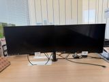 two monitors sitting on a desk next to each other