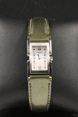 a close up of a wrist watch with a green strap