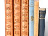 several books are stacked on top of each other on a white surface