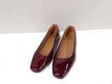 a pair of red shoes sitting on top of a white surface
