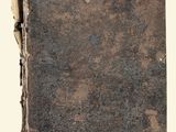 un vieux livre posé sur une table couverte de terre