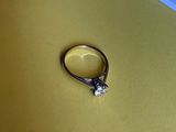 une bague en diamant posée sur une surface jaune