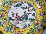 two yellow plates with a painting of a man and a woman on them