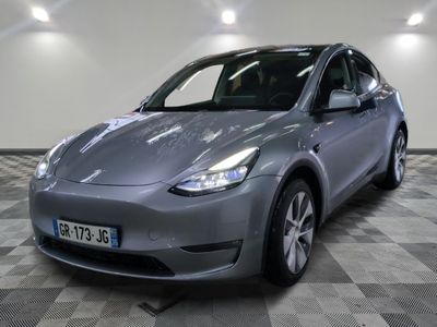 La Tesla Model Y est garée sur un sol carrelé à damier.
