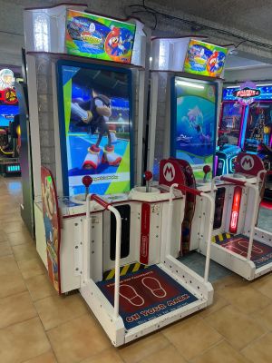 trois bornes d'arcade exposées dans un centre commercial