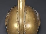 brass helmet on a black surface