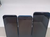 trois iPhones noirs posés les uns à côté des autres sur une table