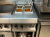 des cuisinières et des fours en acier inoxydable dans une cuisine professionnelle, contenant des aliments