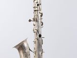 a close up of a silver saxophone with a white background