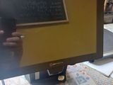 a computer monitor sitting on a desk with a chalkboard on it