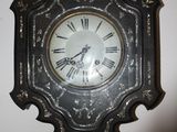 a clock hanging on the wall with roman numerals on it