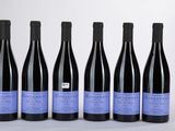 six bouteilles de vin sont alignées sur une table