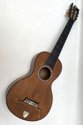 une petite guitare posée sur une surface blanche