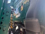 a large green truck that is parked on the side of the road