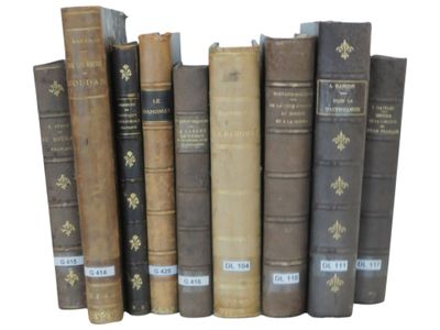 several old books are lined up in a row on a white surface