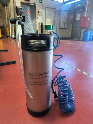 a keg that is sitting on the floor next to a hose