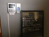 un tableau noir sur lequel est inscrit un menu, à côté d'un téléphone