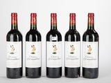 quatre bouteilles de vin rouge sont alignées sur une table