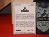 a bottle of beer sitting next to a card on a table