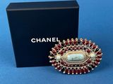 a chanel broochle with red and white stones
