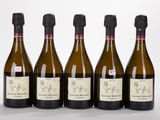 quatre bouteilles de vin sont alignées sur une surface blanche