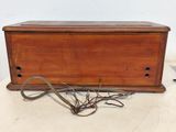 an old wooden box with a wire wrapped around it on top of a table