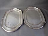pair of silverplated serving dishes on a gray table cloth