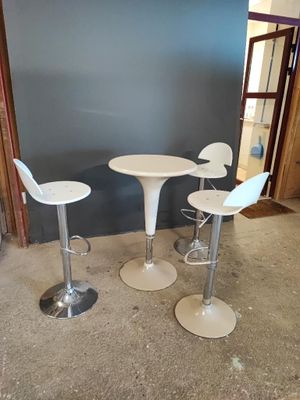 deux chaises blanches et une table dans une pièce
