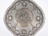 an antique silver plate with a picture of a man and a woman on it