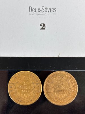deux pièces d'or posées sur une surface noire
