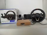 a steering wheel and a game controller sitting on a table