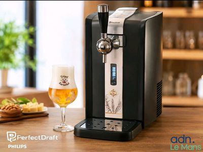 un gros plan sur un distributeur de bière et un verre de bière posé sur une table