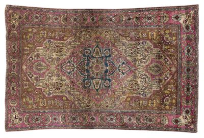 un tapis ancien orné d'un motif en médaillon sur fond rose