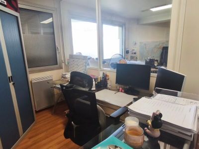 a desk with two computers and a book on it