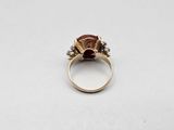 a close up of a gold ring with a red stone