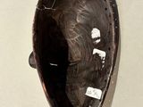 a black and white picture of a mask hanging on a wall