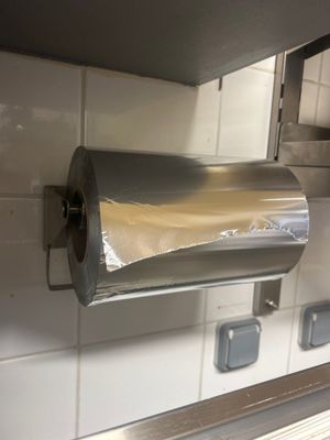 silver paper towel dispenser mounted on a wall in a kitchen