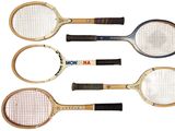 four tennis rackets are lined up on a white surface