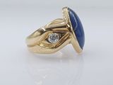 a close up of a gold ring with a blue stone and a diamond